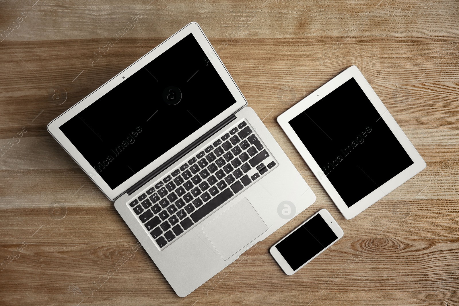 Photo of Devices with blank screens on wooden background, top view. Mock up for design