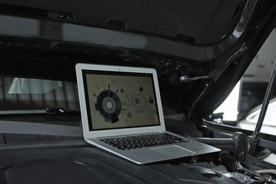 Laptop with diagram on auto engine. Modern car diagnostic