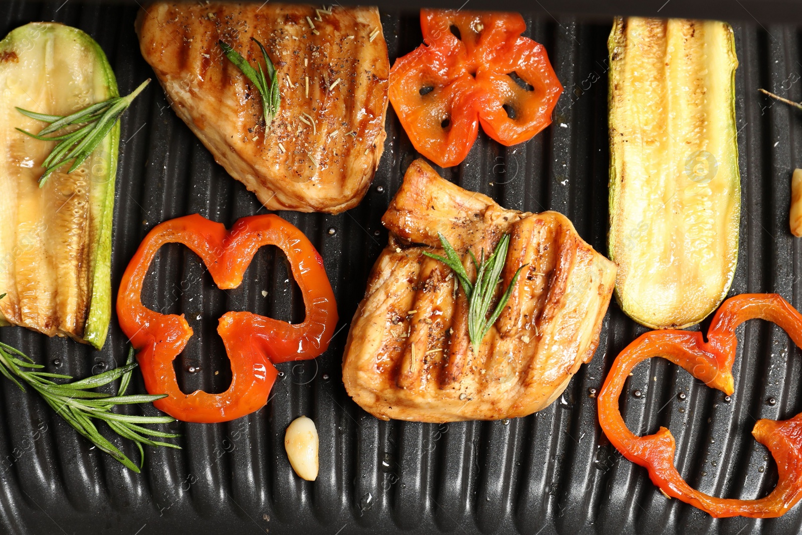 Photo of Tasty meat, spices and vegetables on electric grill, flat lay