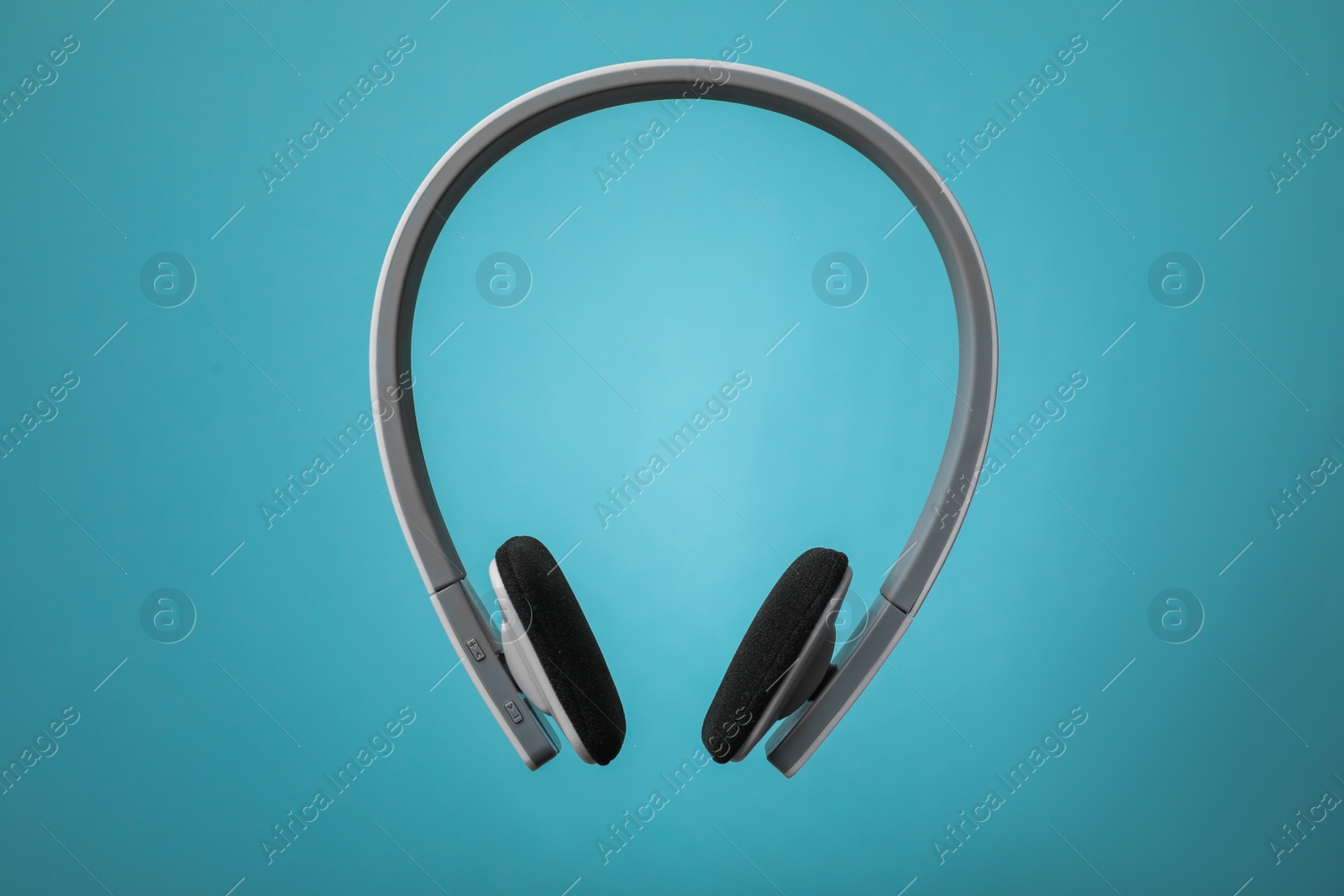 Photo of Wireless headphones with earmuffs on color background