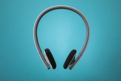 Photo of Wireless headphones with earmuffs on color background