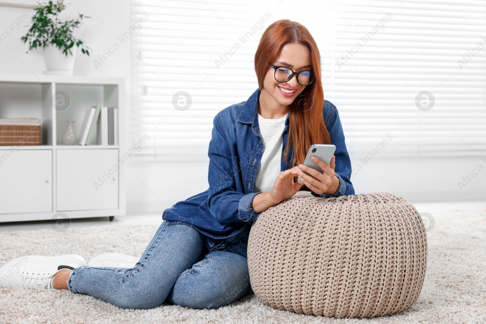 Photo of Happy young woman having video chat via smartphone at home