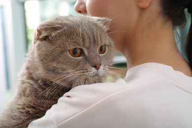 Woman with her adorable cat at home, closeup