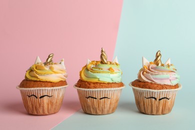 Photo of Cute sweet unicorn cupcakes on color background