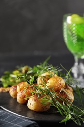 Photo of Delicious grilled potatoes with tarragon on table. Space for text