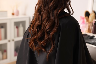 Woman with curly hair sitting in salon, closeup