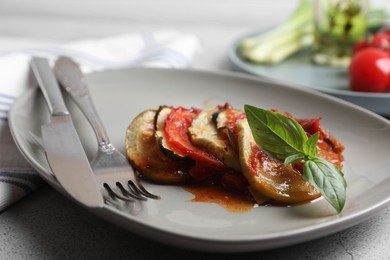 Photo of Delicious ratatouille served with basil on table, closeup