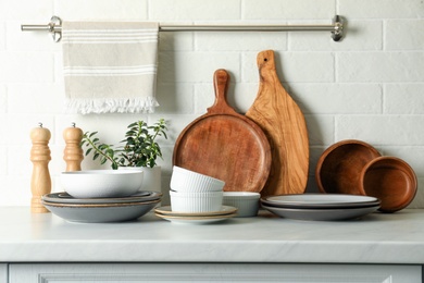 Set of clean tableware on white countertop in kitchen