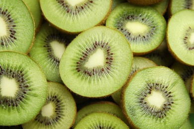 Halves of fresh kiwis as background, above view