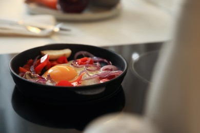 Frying pan with tasty egg and vegetables on stove