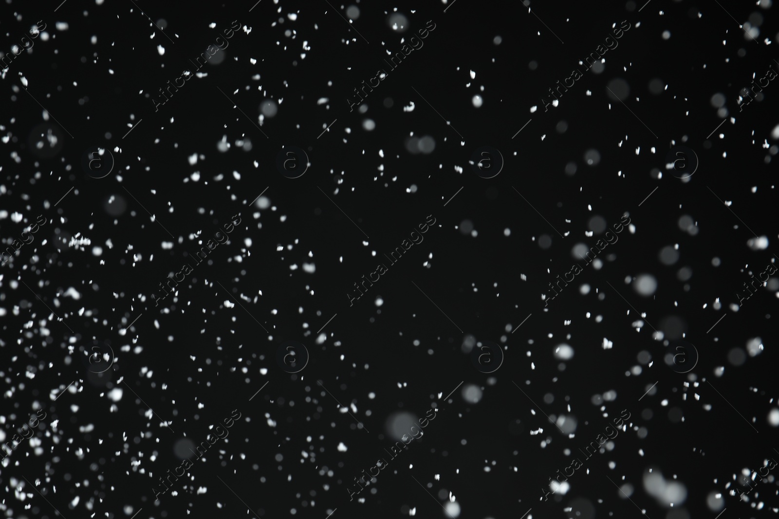 Photo of White snow falling down on black background