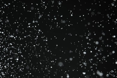 White snow falling down on black background