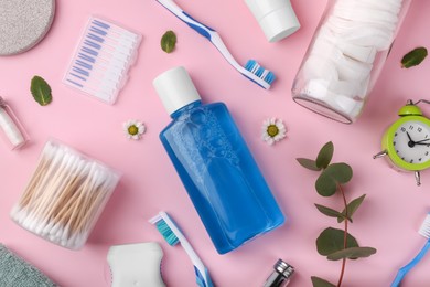 Flat lay composition with fresh mouthwash in bottle and personal care products on pink background. Daily routine