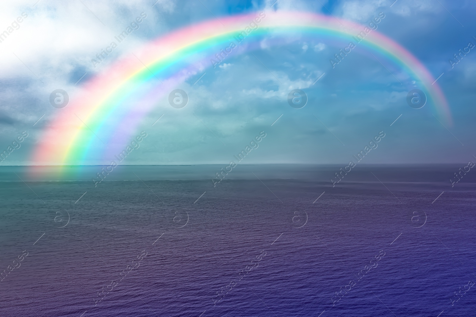 Image of Beautiful view of colorful rainbow in sky over sea