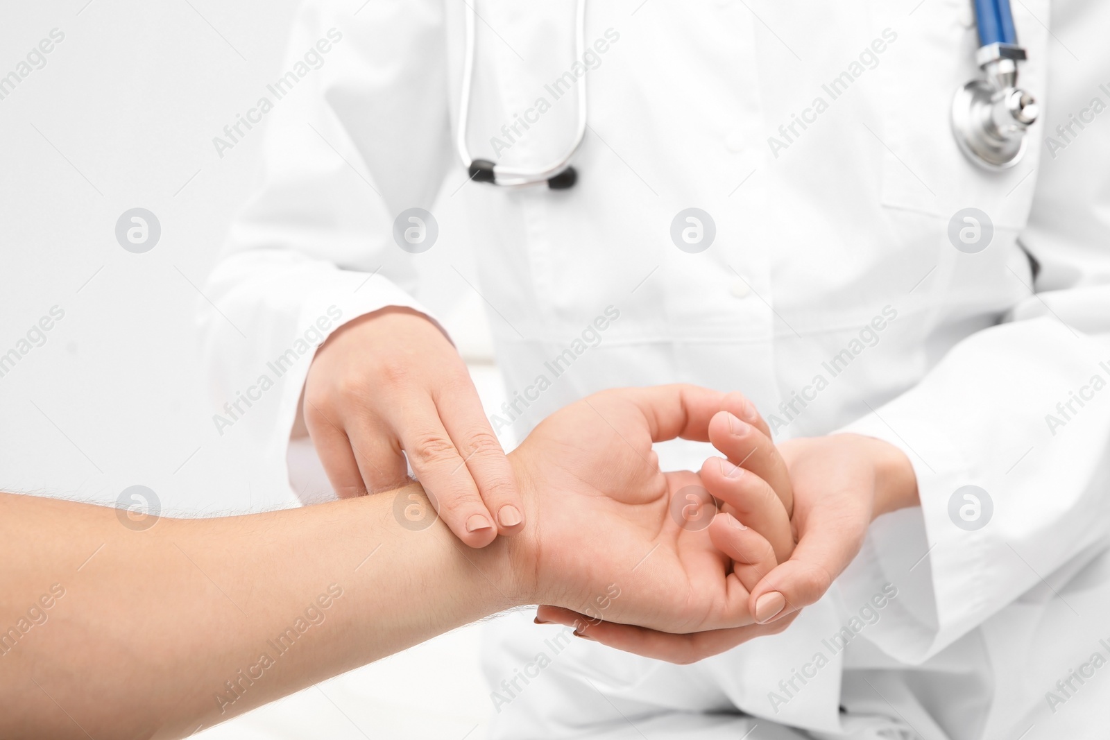 Photo of Doctor checking young man's pulse in hospital