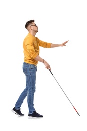 Blind man in dark glasses with walking cane on white background