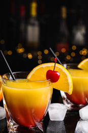 Photo of Fresh alcoholic Tequila Sunrise cocktail on black table
