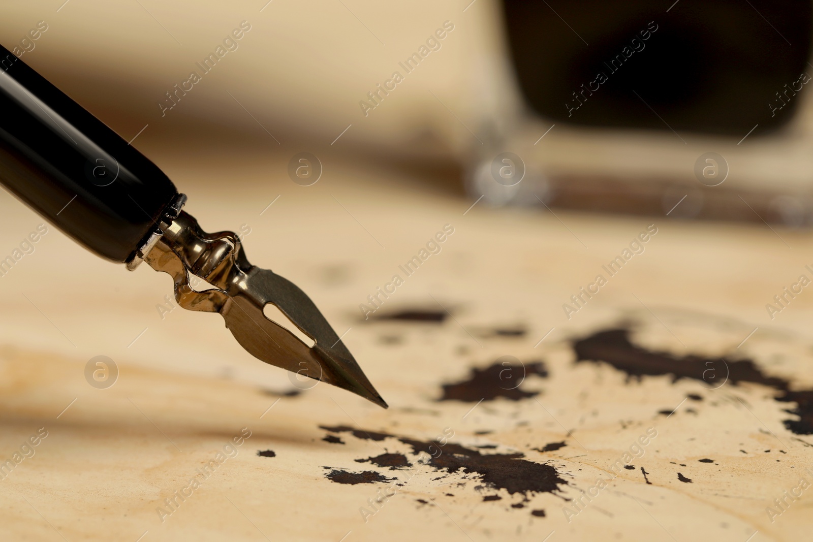 Photo of Fountain pen and vintage parchment with ink stains, closeup. Space for text