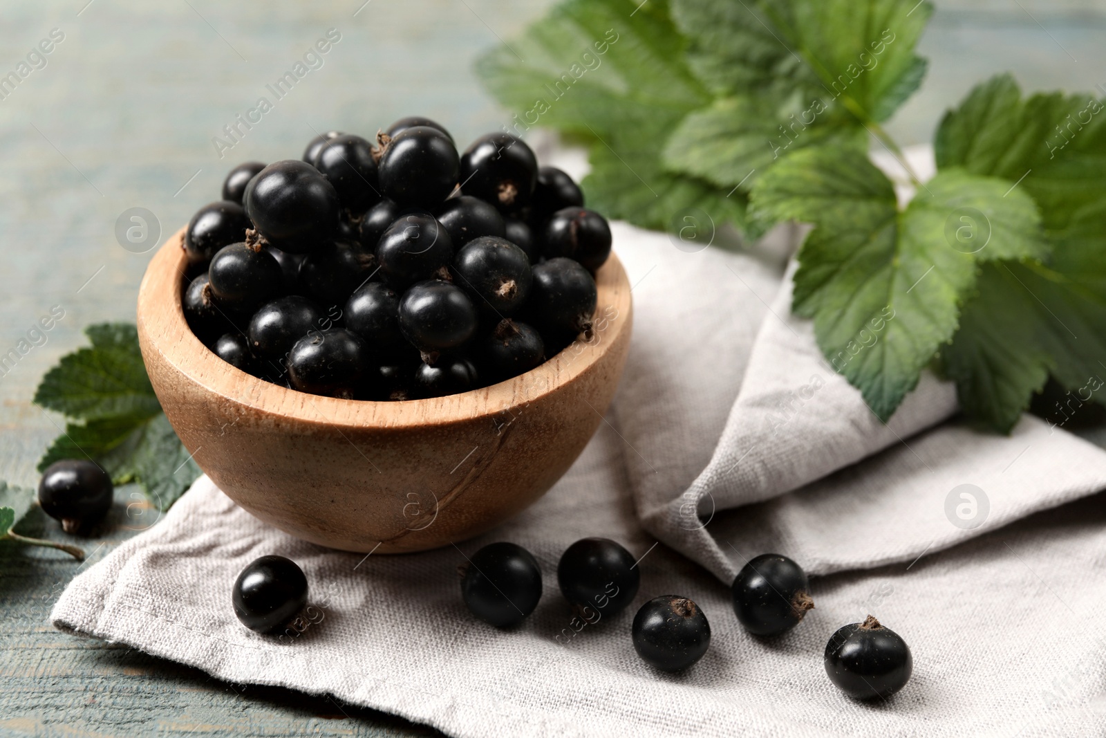 Photo of Ripe blackcurrants and leaves on wooden rustic table