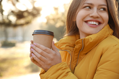 Photo of Young woman with cup of coffee in morning outdoors