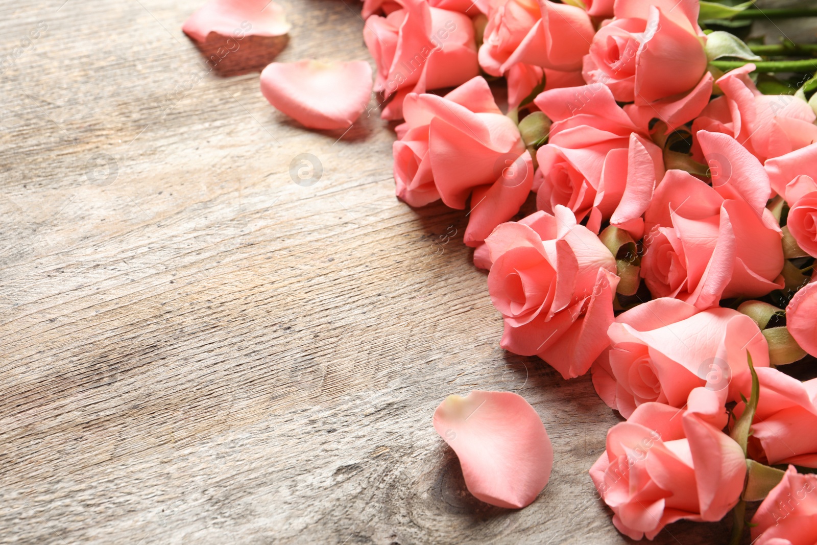 Photo of Beautiful roses on wooden table