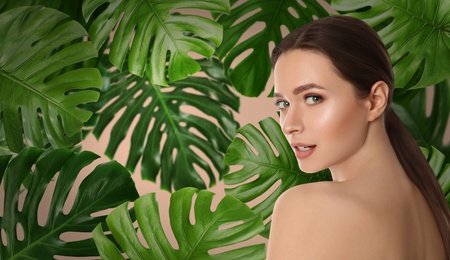 Image of Beautiful young woman and tropical leaves, banner design. Spa portrait