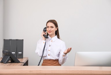 Female receptionist talking on phone at workplace