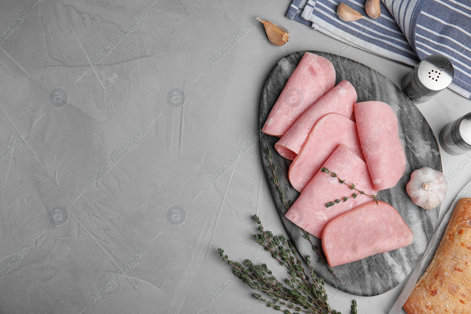 Photo of Tasty ham served on light grey table, flat lay. Space for text