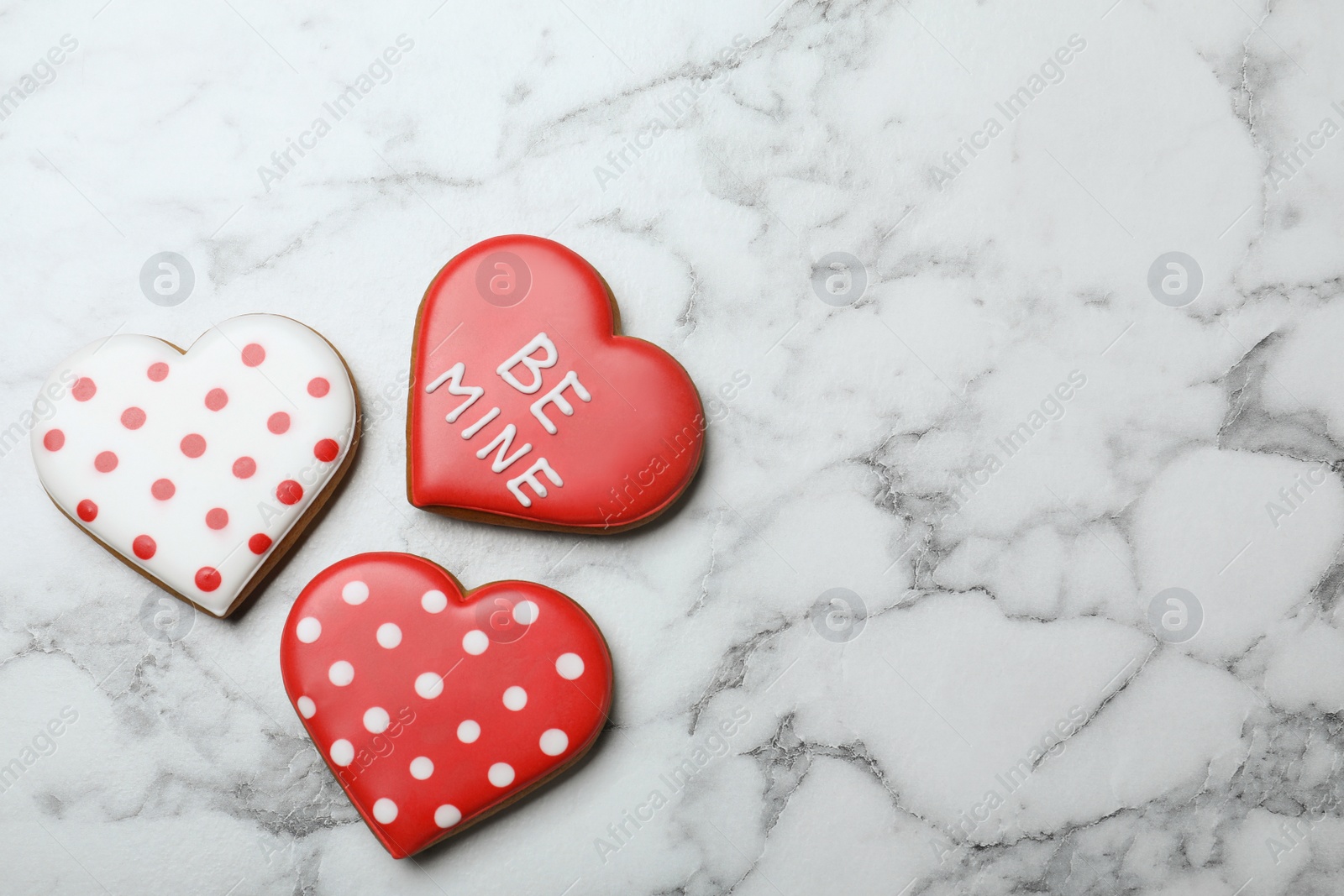 Photo of Valentine's day cookies on white marble table, flat lay. Space for text