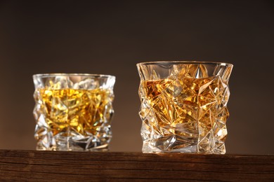 Photo of Whiskey in glasses on wooden table, low angle view
