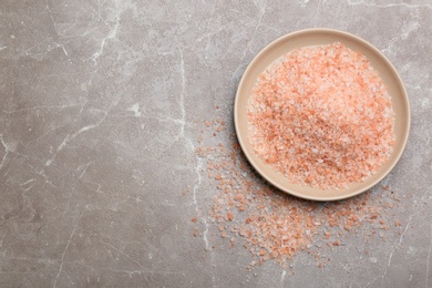 Pink himalayan salt on grey table, flat lay. Space for text