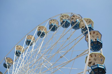 Photo of Large observation wheel against blue sky, low angle view