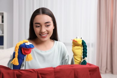 Happy woman performing puppet show at home