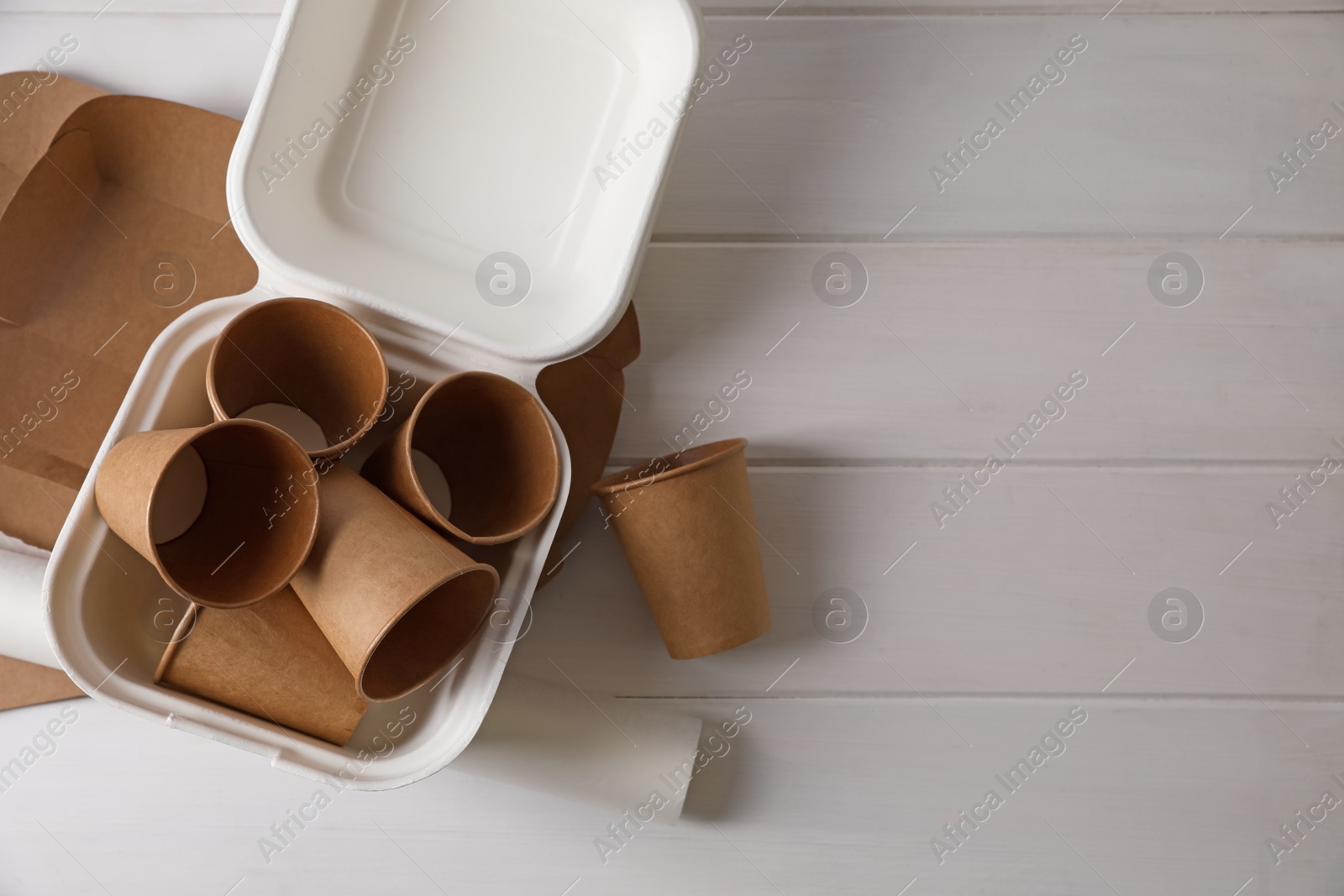 Photo of Heap of waste paper on white wooden table, flat lay. Space for text