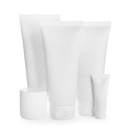 Photo of Blank tubes and jars of cosmetic products on white background