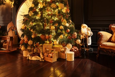Beautiful Christmas tree, many gift boxes and vintage armchair in room