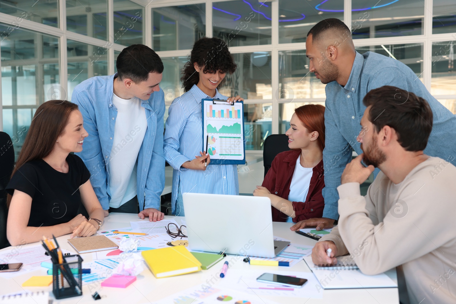 Photo of Team of employees working together at table in office. Startup project