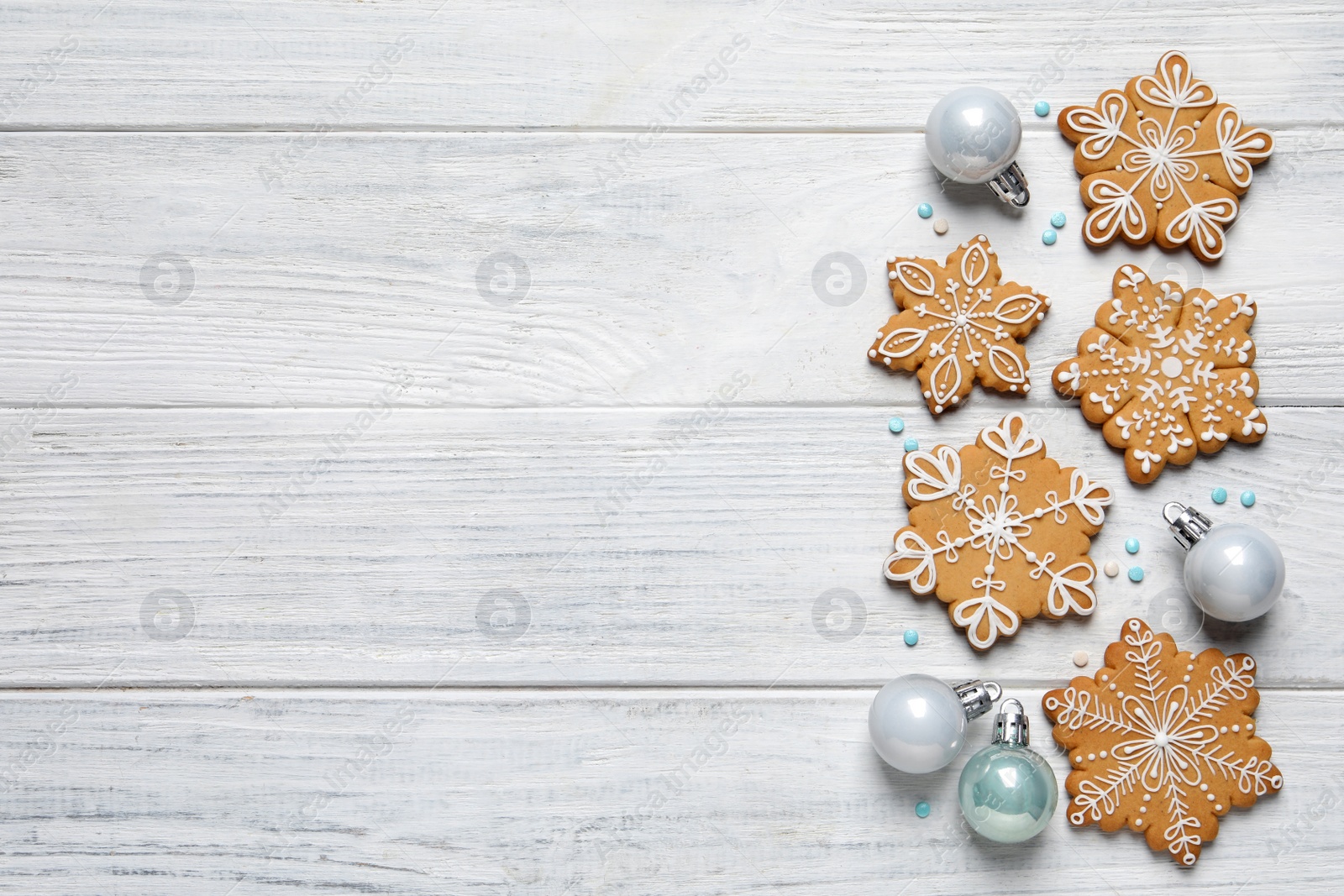 Photo of Tasty Christmas cookies and baubles on white wooden table, flat lay. Space for text
