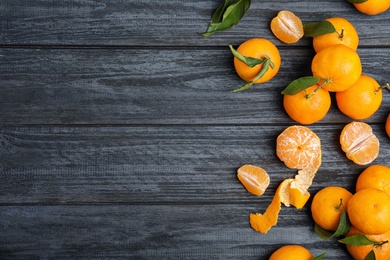 Photo of Fresh ripe tangerines and space for text on wooden background, top view