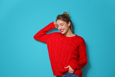 Photo of Beautiful young woman in warm sweater on color background