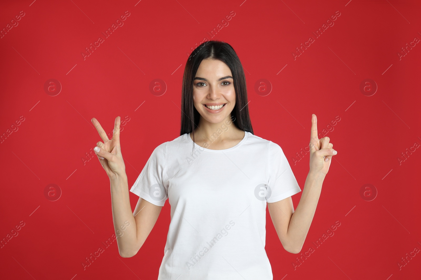 Photo of Woman showing number three with her hands on red background