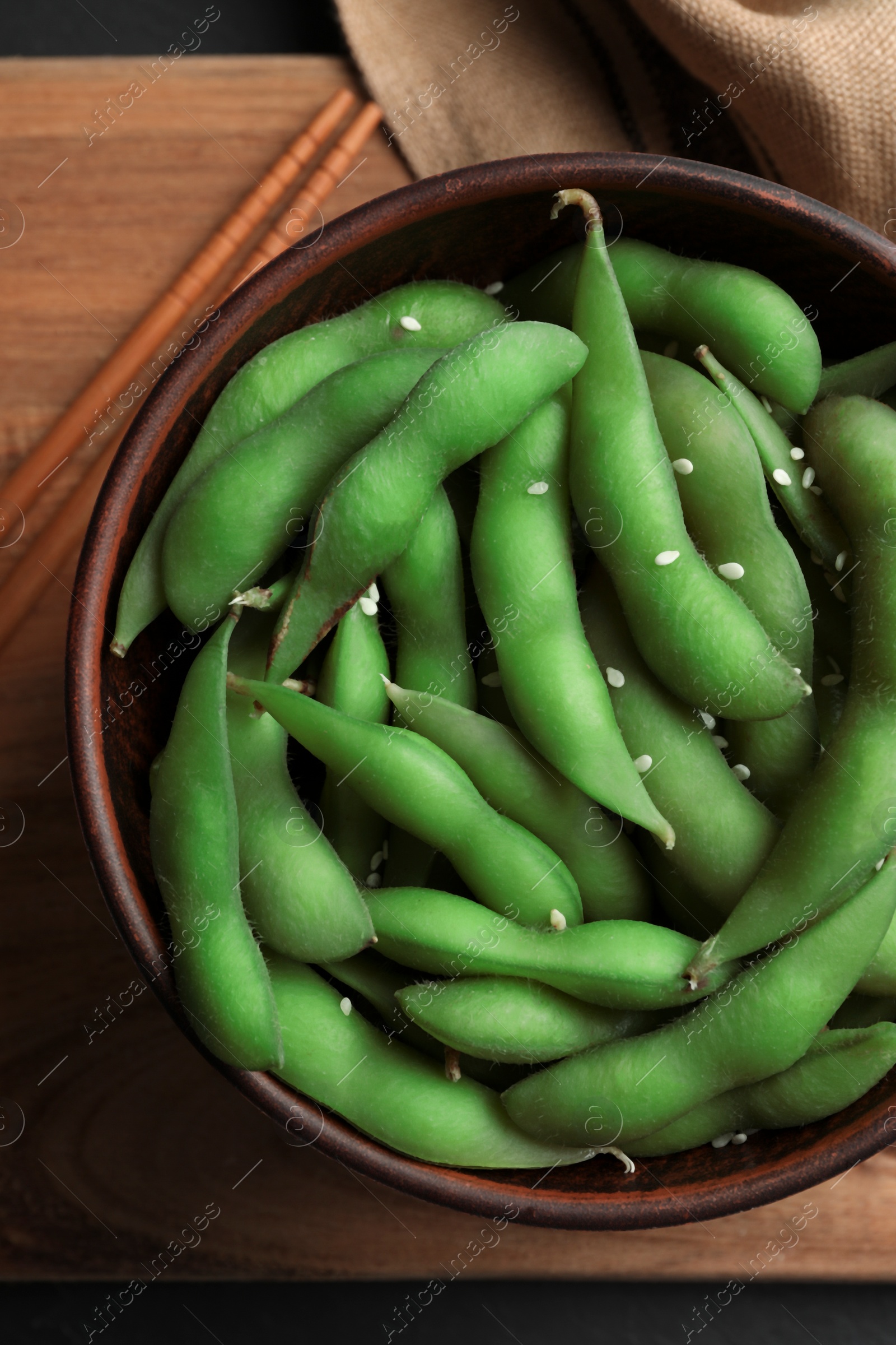 Photo of Green edamame beans in pods served on wooden table, flat lay