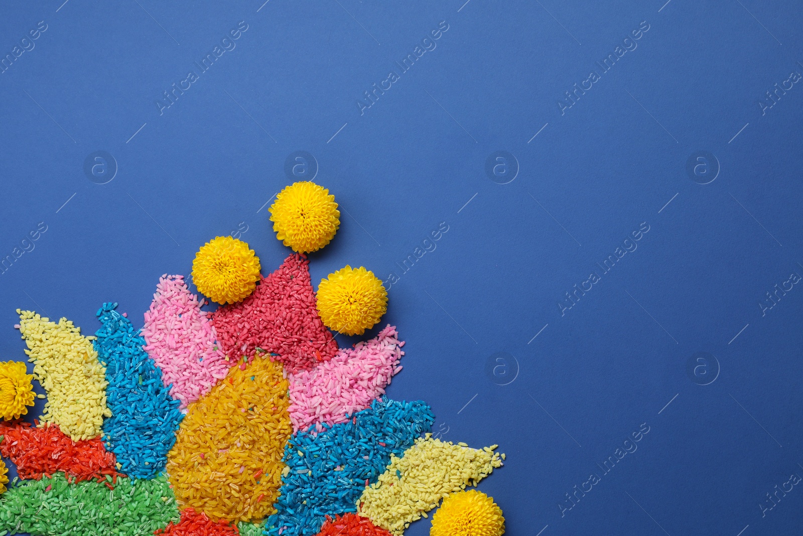 Photo of Diwali celebration. Colorful rangoli on blue background, top view. Space for text