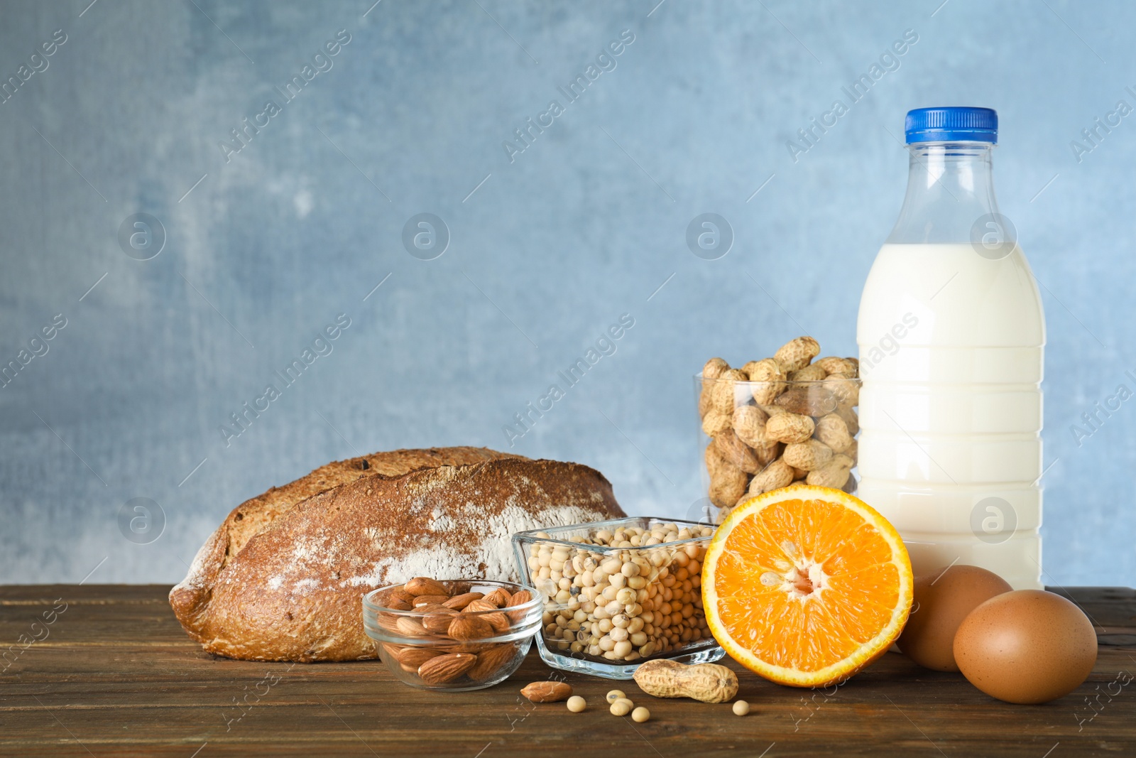 Photo of Set of natural products on wooden table against light blue background, space for text. Food allergy