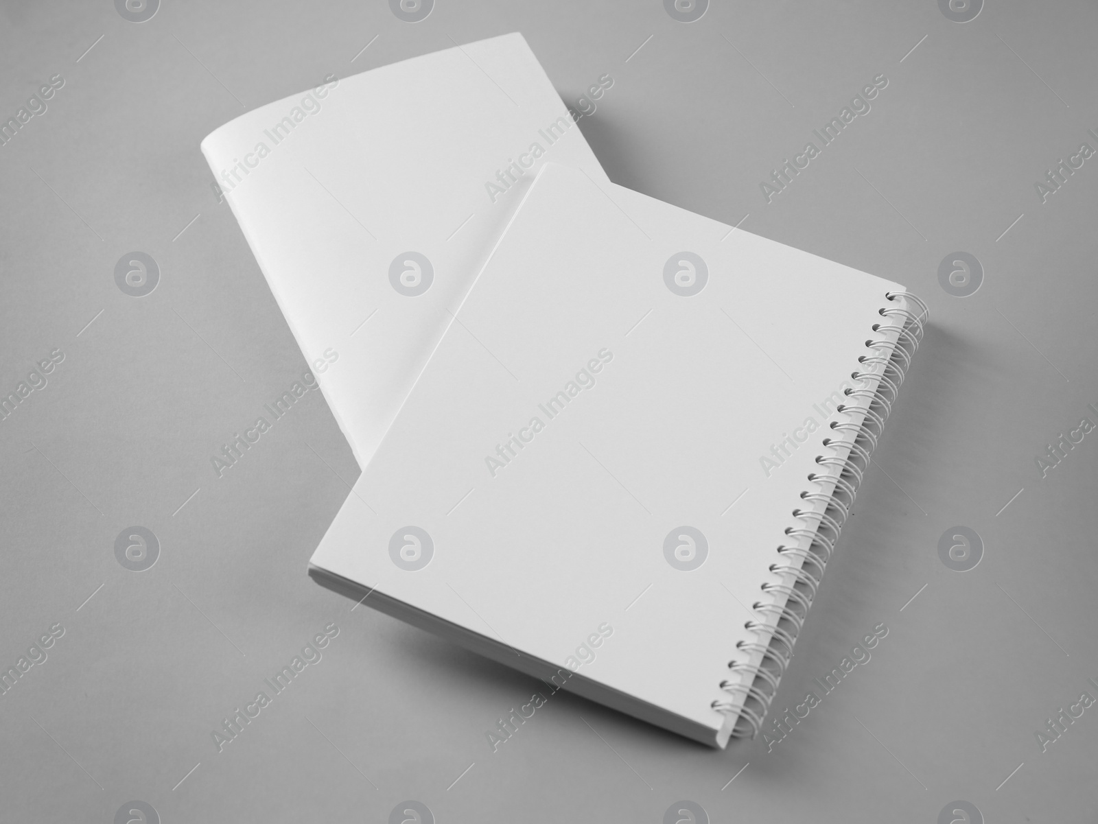 Photo of Blank brochure and notebook on grey background. Mockup for design