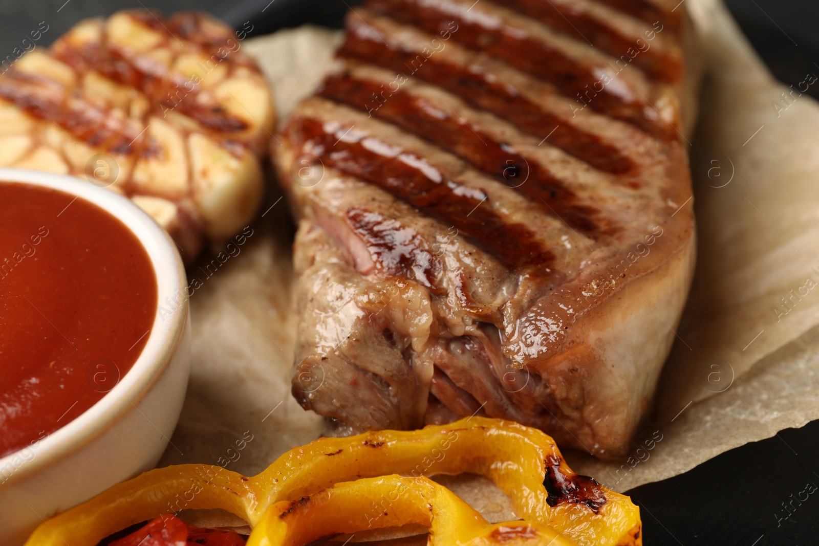 Photo of Delicious grilled beef steak with vegetables on table, closeup