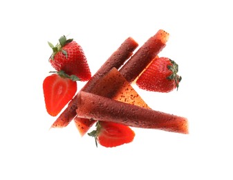 Delicious fruit leather rolls and strawberries on white background, top view