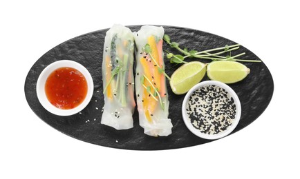 Tasty spring rolls, sauce, lime, sesame seeds and microgreens isolated on white, top view