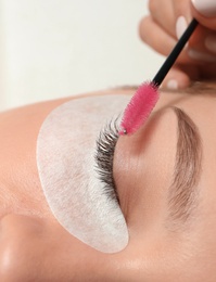 Photo of Young woman undergoing eyelash extension procedure, closeup