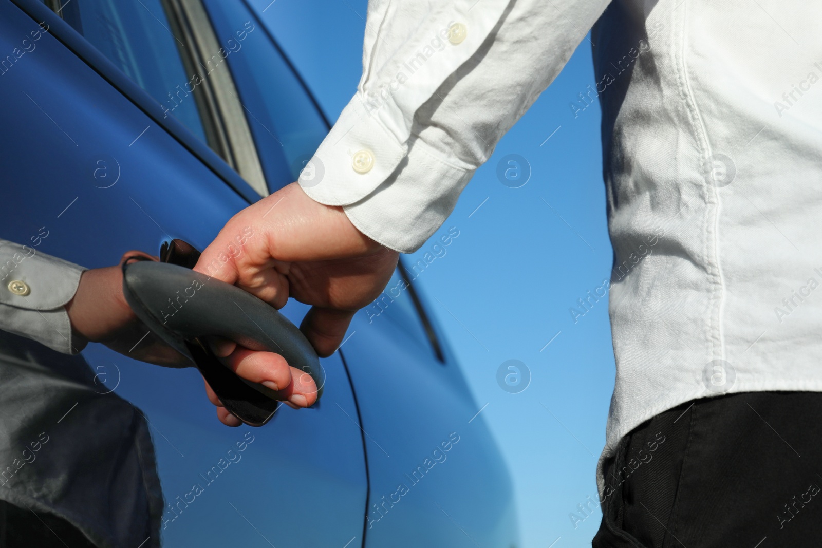 Photo of Closeup view of man opening car door